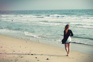 Woman walking on beach - escharotic therapy 